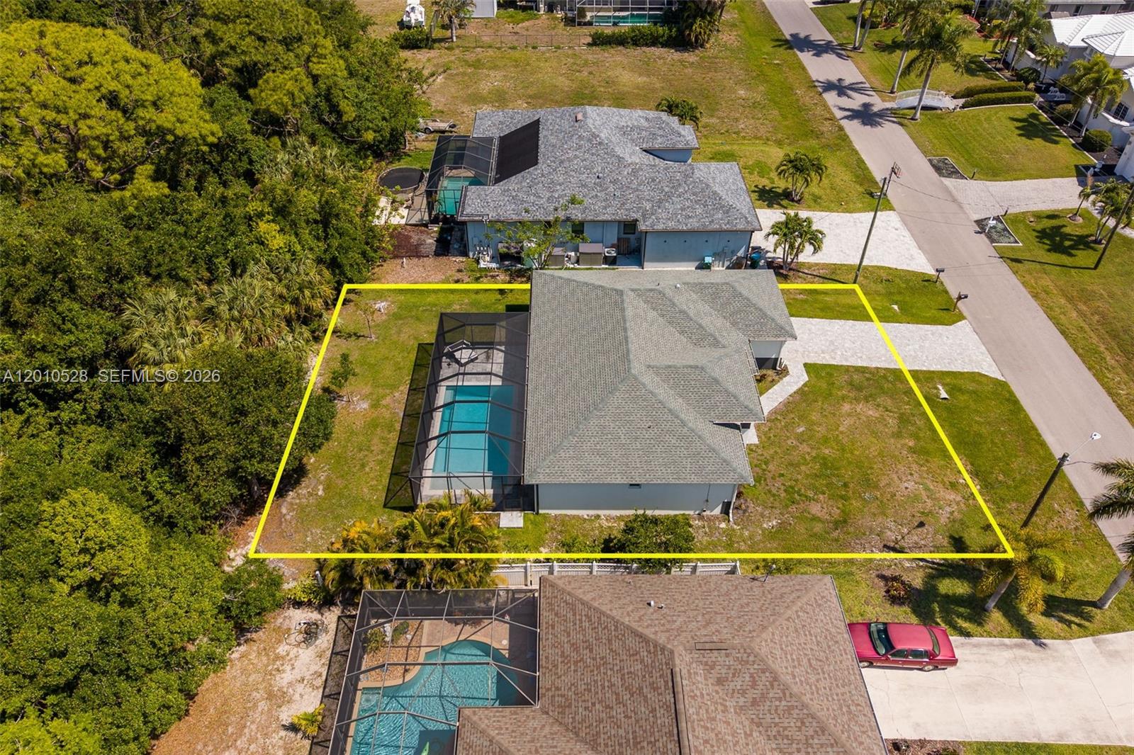 An aerial view shows a house with a screened-in pool and a fenced yard — 1746 NW 26th AVE, Cape Coral FL 33993, CAPE CORAL, FL