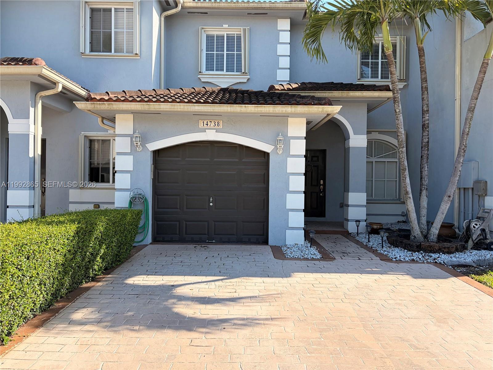 A two-story house exterior features a paved driveway, a garage, and a palm tree — 14738 SW 22nd Ter, Miami FL 33185, MIAMI, FL