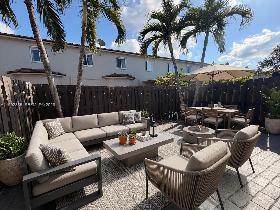A patio features a sectional sofa, armchairs, a dining set, and palm trees against a fence — 14738 SW 22nd Ter, Miami FL 33185, MIAMI, FL