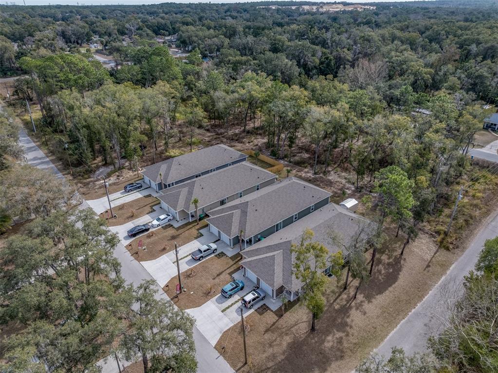 An aerial view shows a row of attached townhomes surrounded by a wooded area — 6408 W FLANDERS LANE, CRYSTAL RIVER, FL