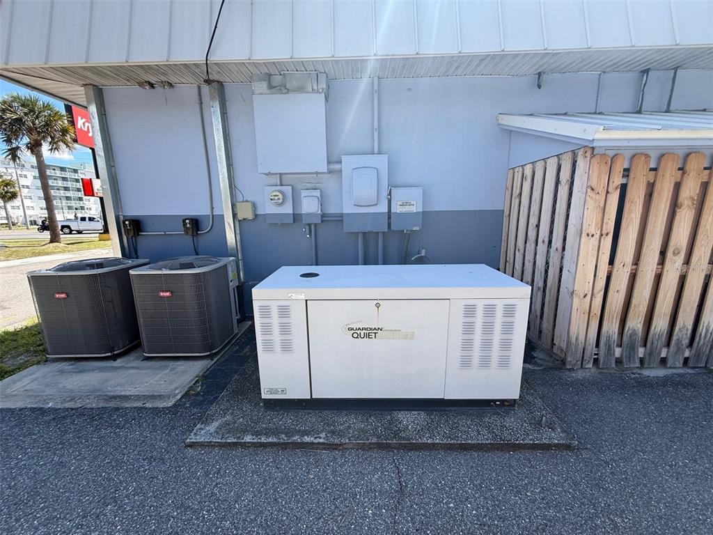 An outdoor area shows a large standby generator next to two HVAC units and fencing — 2916 S WASHINGTON AVENUE, TITUSVILLE, FL