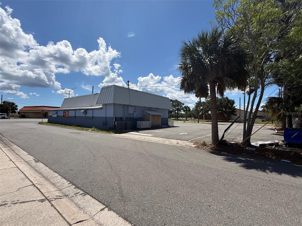 The exterior of a commercial building features a metal roof and a paved parking lot — 2916 S WASHINGTON AVENUE, TITUSVILLE, FL