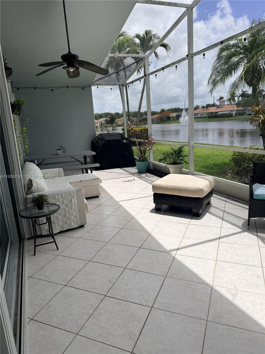 A screened-in patio features tile flooring, a ceiling fan, and a view of a lake — 10390 E Utopia Cir E # 10390, Boynton Beach FL 33437, BOYNTON BEACH, FL