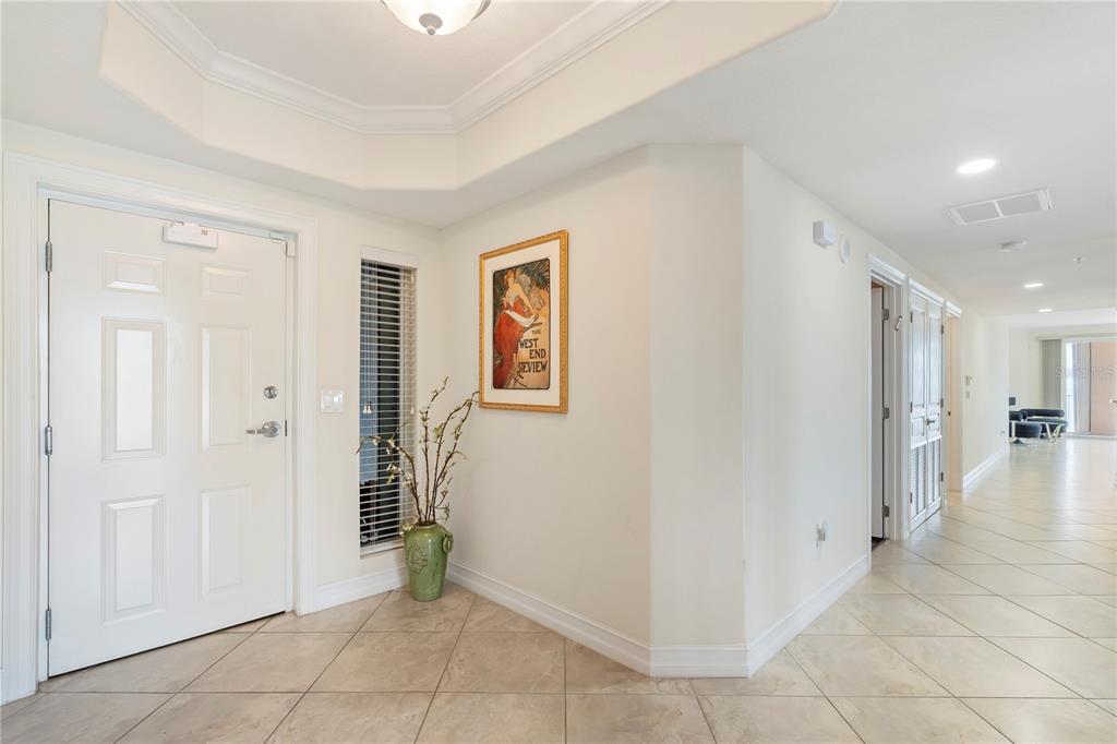 A bright entryway features white walls, tile flooring, a front door, and a framed poster — 4180 N HIGHWAY A1A UNIT 305B, HUTCHINSON ISLAND, FL