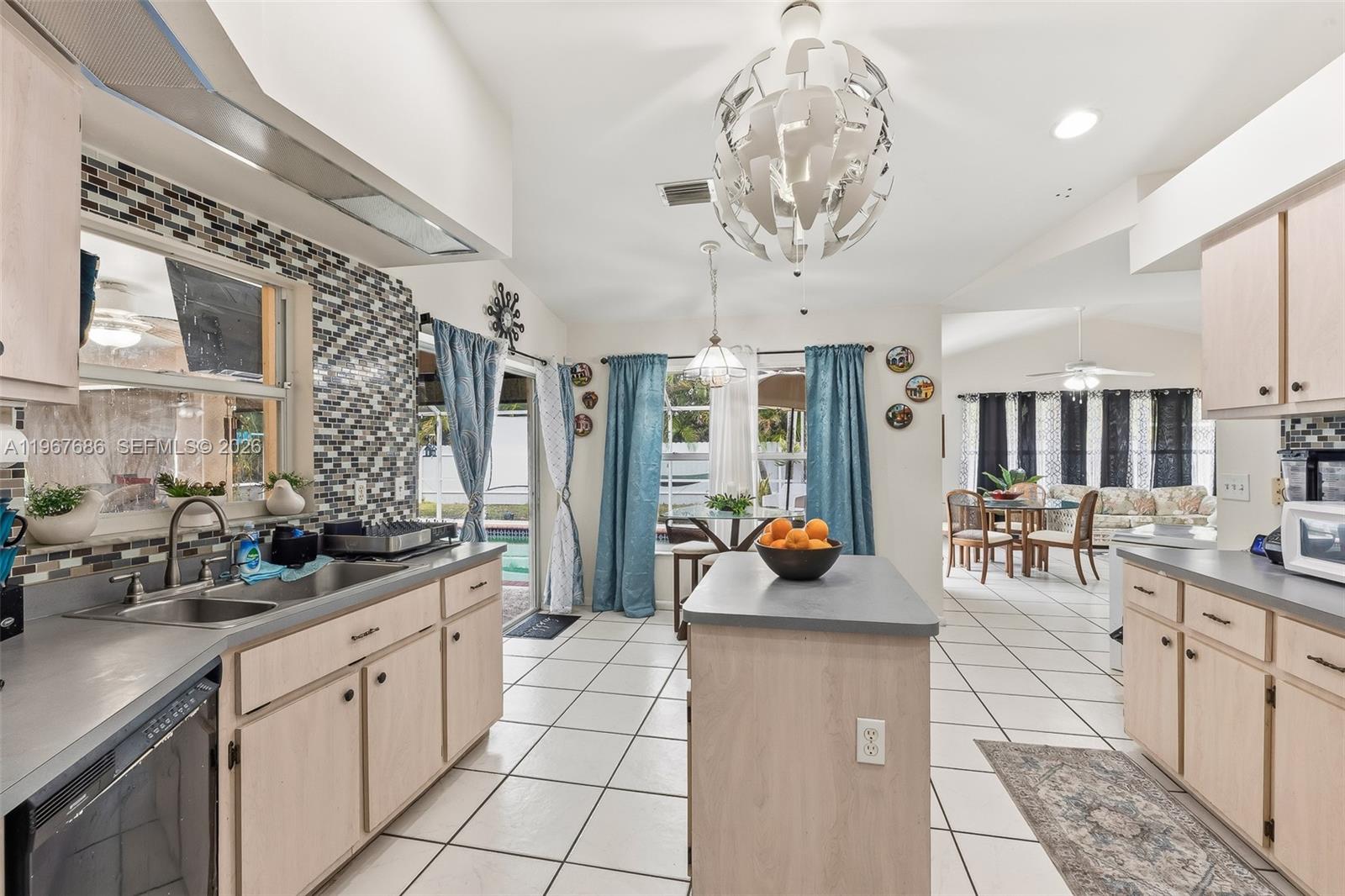 A kitchen with light wood cabinets, a central island, and a tiled floor — 1203 SE 27th ST, Cape Coral FL 33904, CAPE CORAL, FL