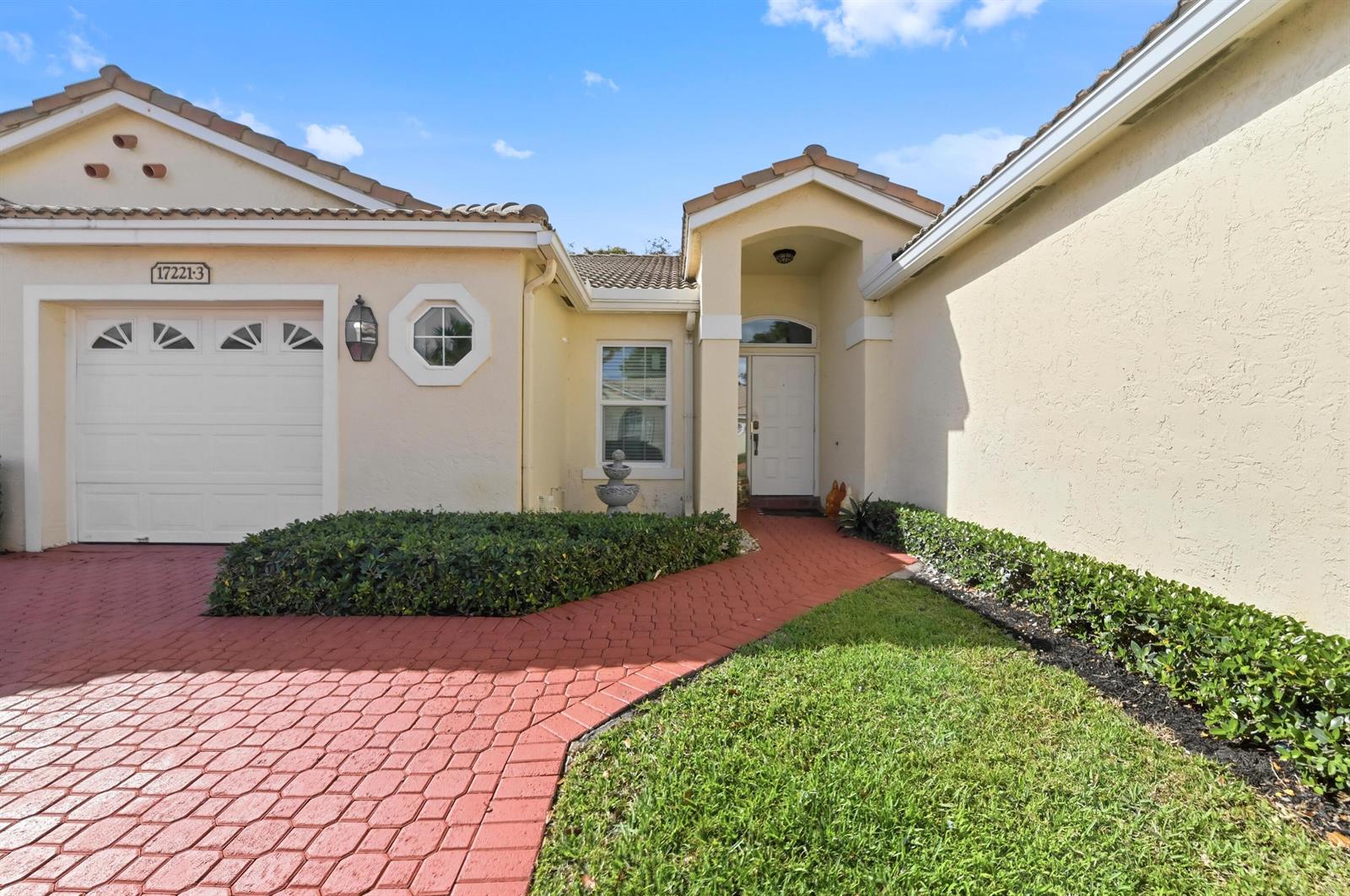 The exterior of a beige house features a red paved driveway, walkway, and front door — 17221 Boca Club Boulevard # 3, Boca Raton FL 33487, BOCA RATON, FL