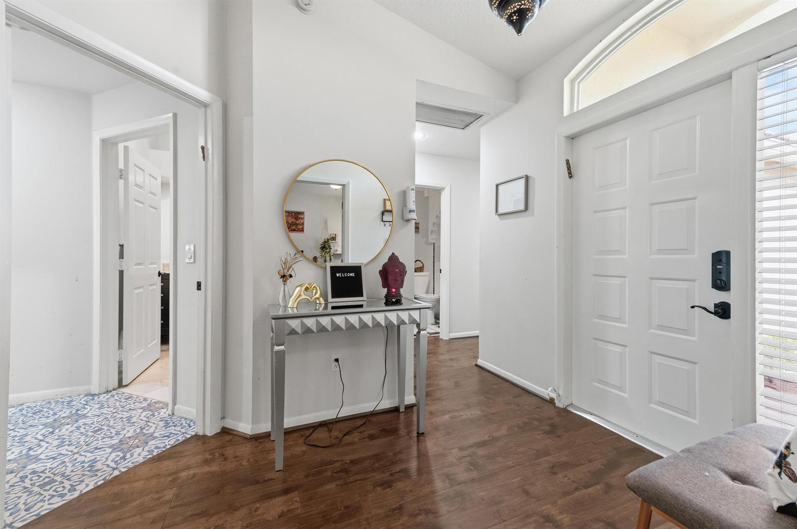 An entryway features wood-look flooring, a mirrored console table, a round mirror, and white doors — 17221 Boca Club Boulevard # 3, Boca Raton FL 33487, BOCA RATON, FL