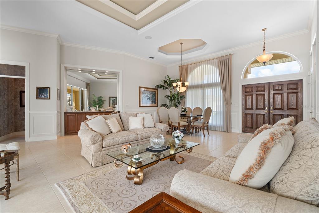 A spacious living room features tile floors, a coffered ceiling, and a dining area — 3366 TRINIDAD COURT, PUNTA GORDA, FL