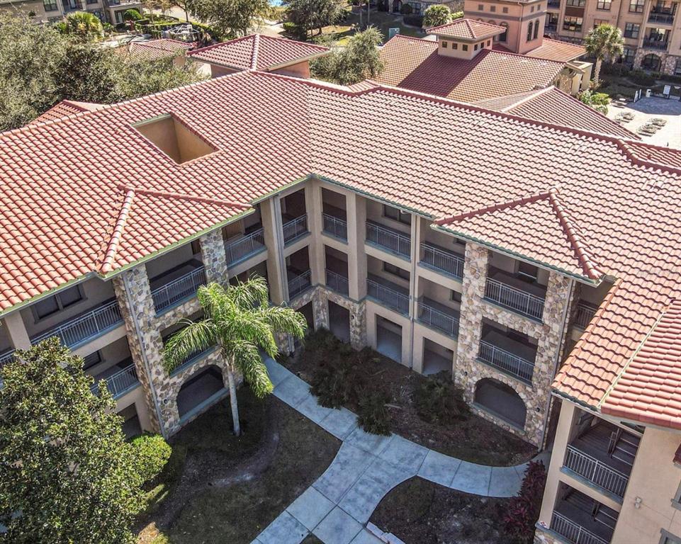 An aerial view of a multi-story apartment building with a tiled roof and courtyard — 903 CHARO PARKWAY UNIT 837, DAVENPORT, FL