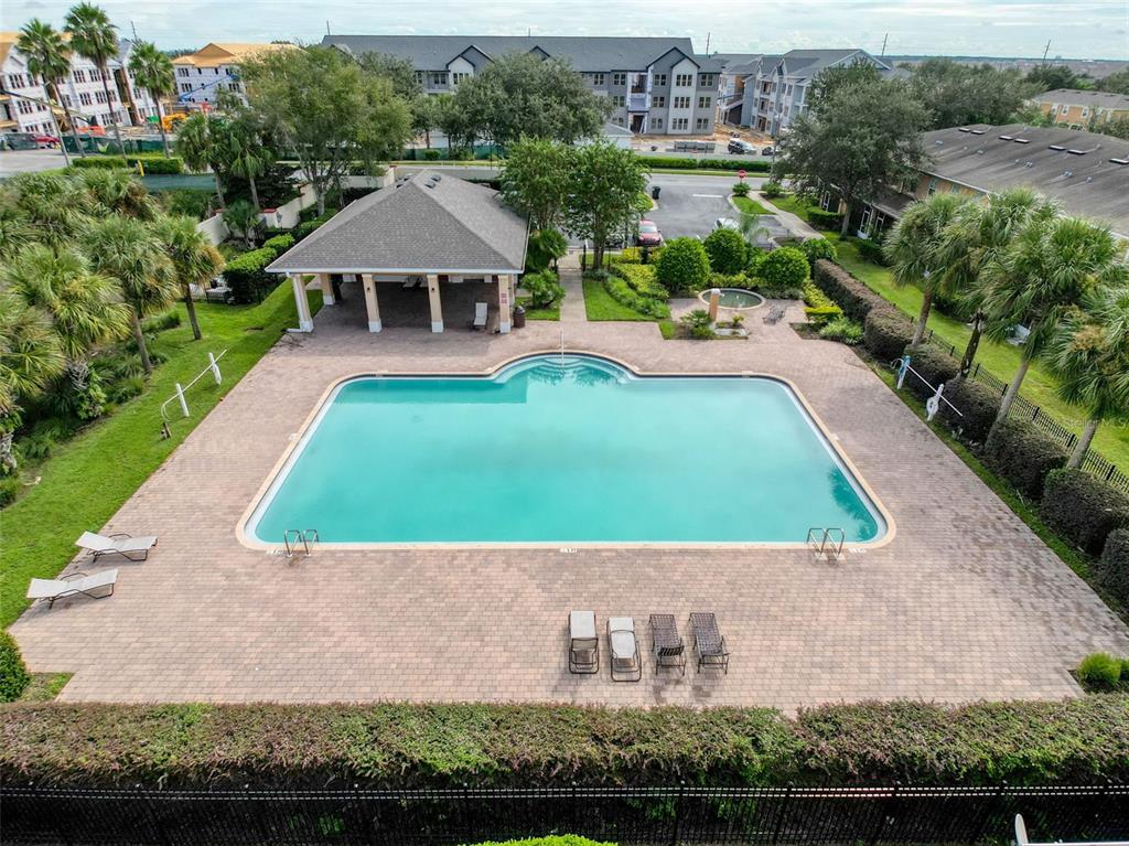 An aerial view of a rectangular swimming pool with a covered pavilion and lounge chairs — 335 BEXLEY DRIVE, DAVENPORT, FL