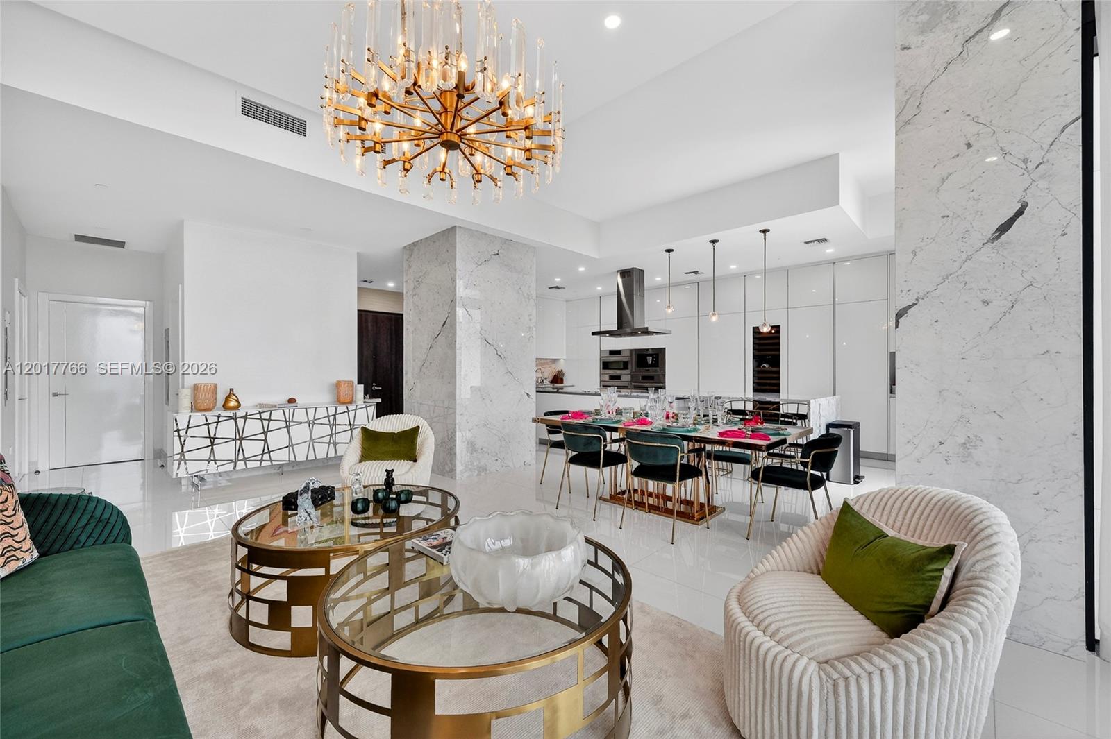 A modern open-concept living and dining area features marble columns, gold accents, and a chandelier — 88 SW 7th St, Miami FL 33130, MIAMI, FL