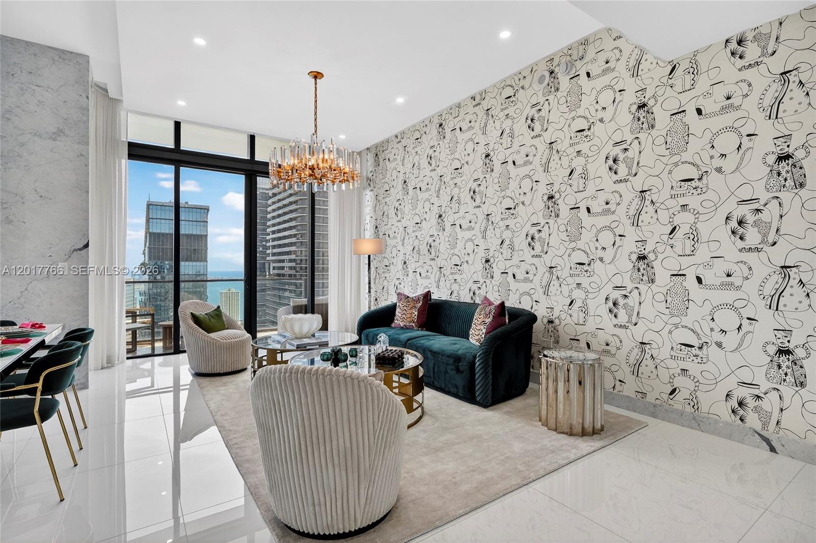 A modern living room features patterned wallpaper, a teal velvet sofa, and floor-to-ceiling windows — 88 SW 7th St, Miami FL 33130, MIAMI, FL