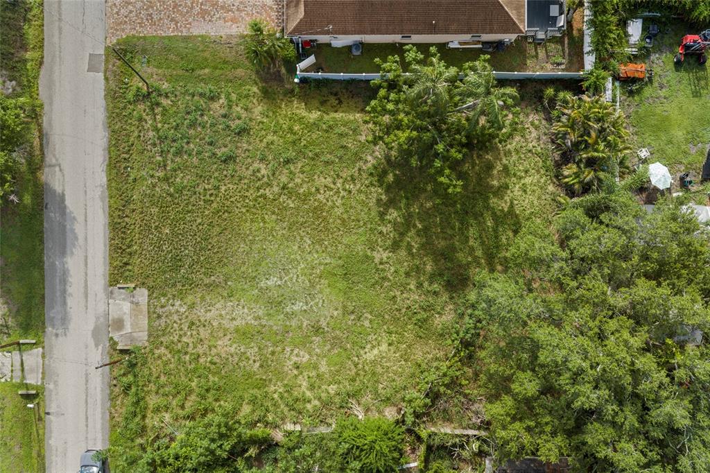 A vacant, grassy residential lot sits next to a house with a white fence — 2930 HAWTHORNE STREET, SARASOTA, FL