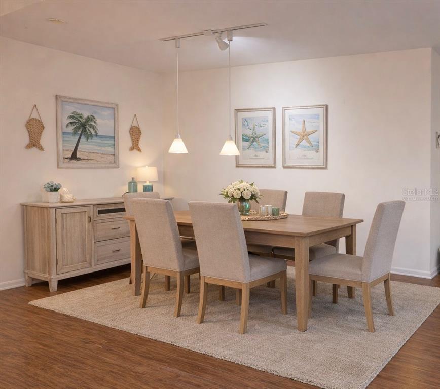 A dining room features a wooden table, six upholstered chairs, a sideboard, and coastal decor — 5300 S ATLANTIC AVENUE UNIT 8-401, NEW SMYRNA BEACH, FL