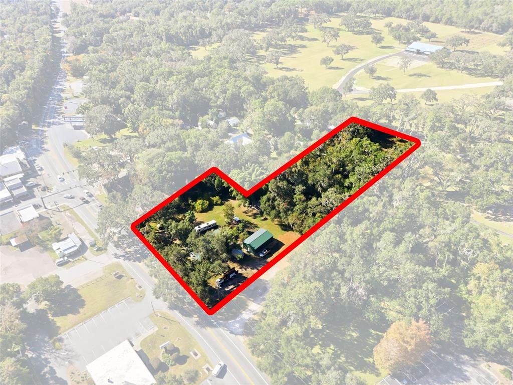 An aerial view shows a wooded lot with a small building and a trailer — 7698 S FLORIDA AVENUE UNIT 1, FLORAL CITY, FL