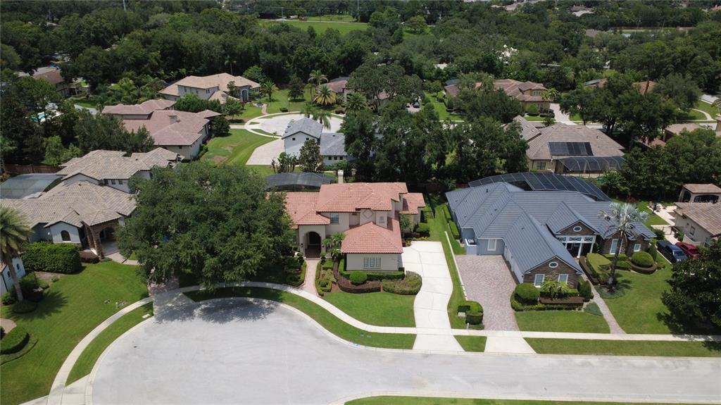 An aerial view shows several suburban houses with tiled roofs and driveways in a neighborhood — 3318 SUNSET VIEW COURT, LONGWOOD, FL