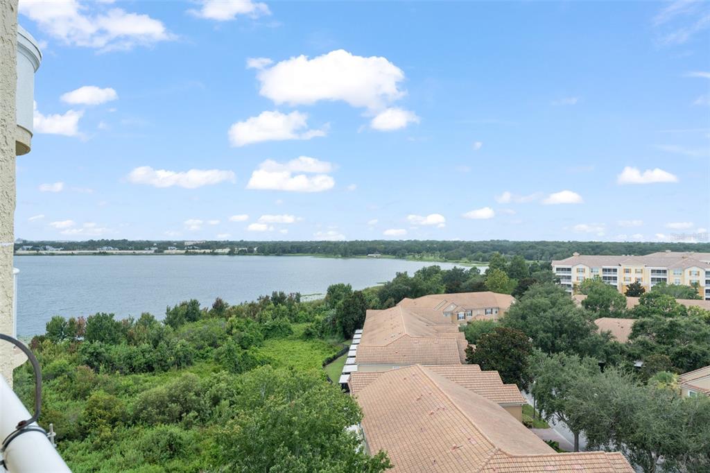 An elevated view of a lake surrounded by trees and residential buildings under a cloudy sky — 6336 BUFORD STREET UNIT 809, ORLANDO, FL