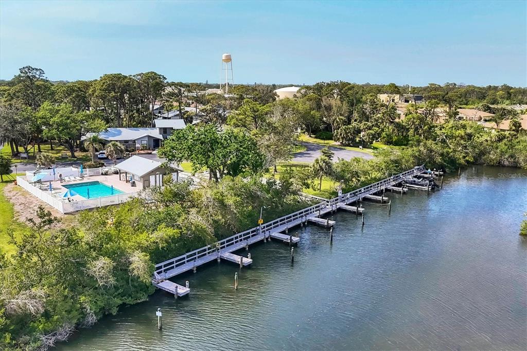An aerial view shows a swimming pool, a long wooden dock, and a water tower — 106 JOSE GASPAR DRIVE UNIT 106, ENGLEWOOD, FL