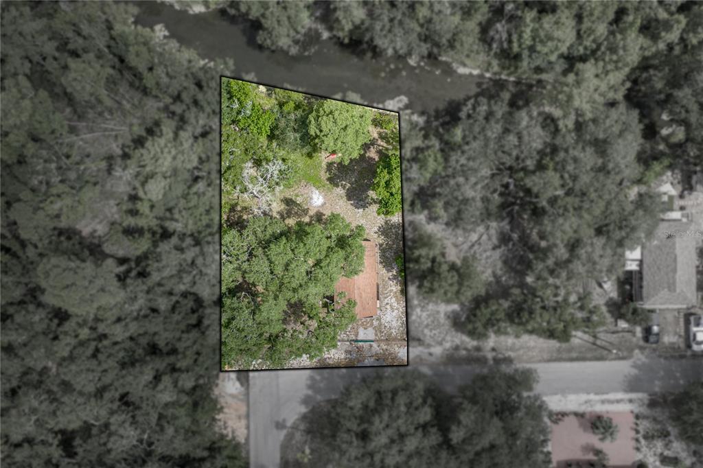 An aerial view shows a house on a wooded lot bordering a river — 33065 CEDONIA ROAD, DADE CITY, FL