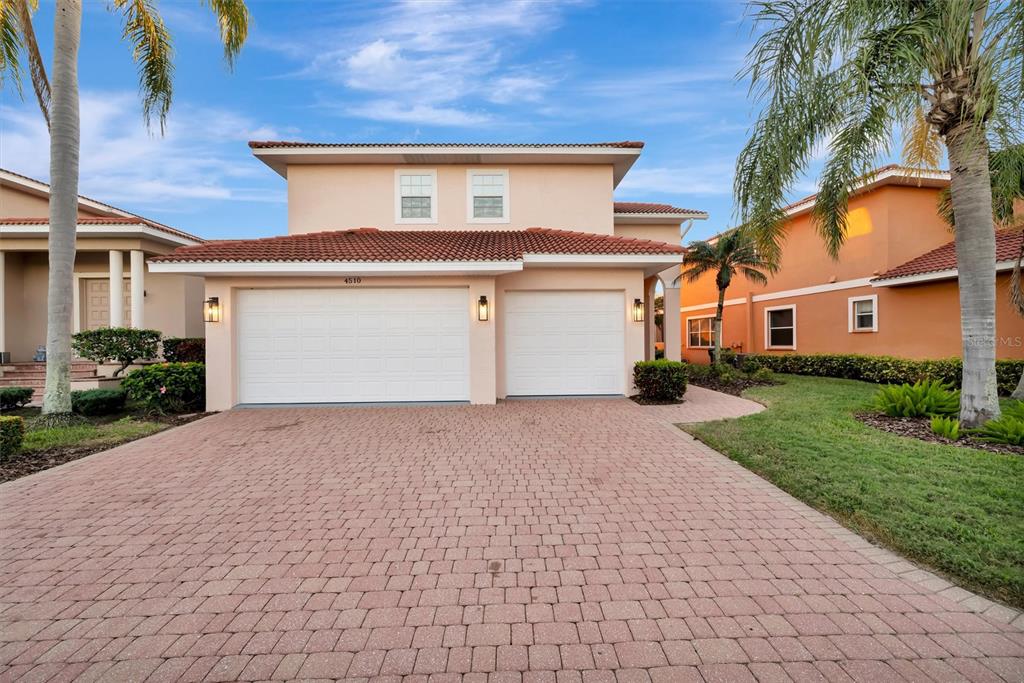 A two-story house with a two-car garage and a paved driveway under a blue sky — 4510 MURCIA BOULEVARD UNIT 16, SARASOTA, FL