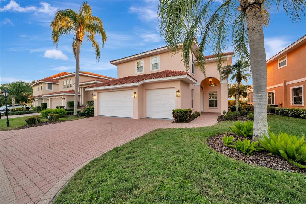 A two-story peach-colored house with a two-car garage and a brick paver driveway — 4510 MURCIA BOULEVARD UNIT 16, SARASOTA, FL