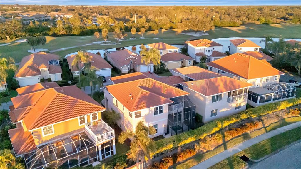 An aerial view shows several suburban houses with orange tile roofs near a golf course — 4510 MURCIA BOULEVARD UNIT 16, SARASOTA, FL