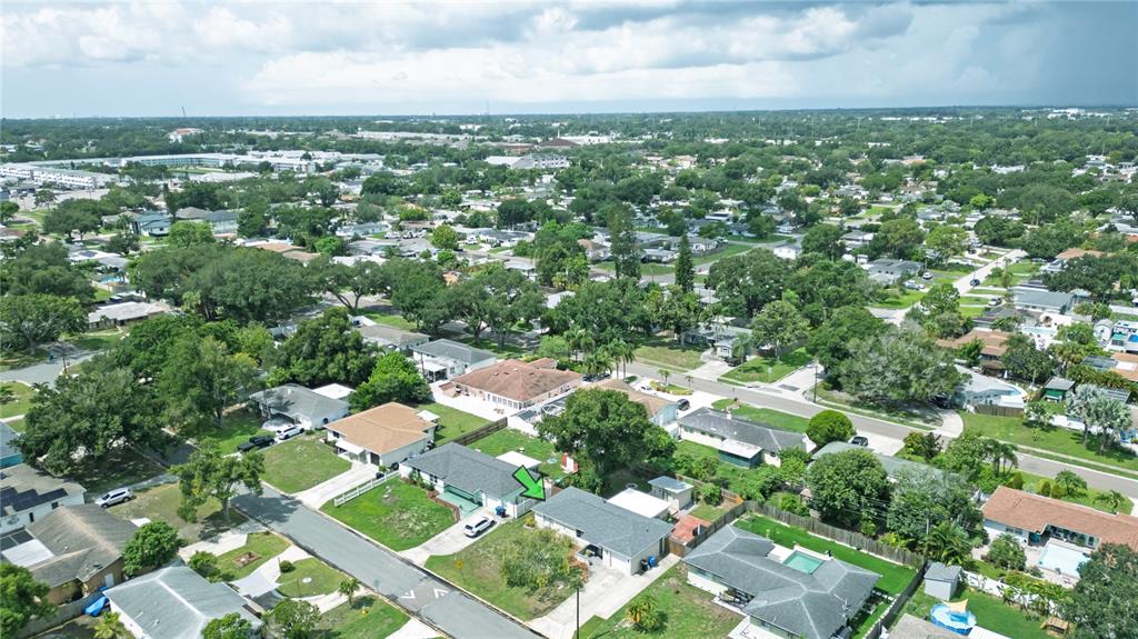 An aerial view shows a suburban neighborhood with single-family homes, green lawns, and mature trees — 6724 17TH LANE N, ST PETERSBURG, FL