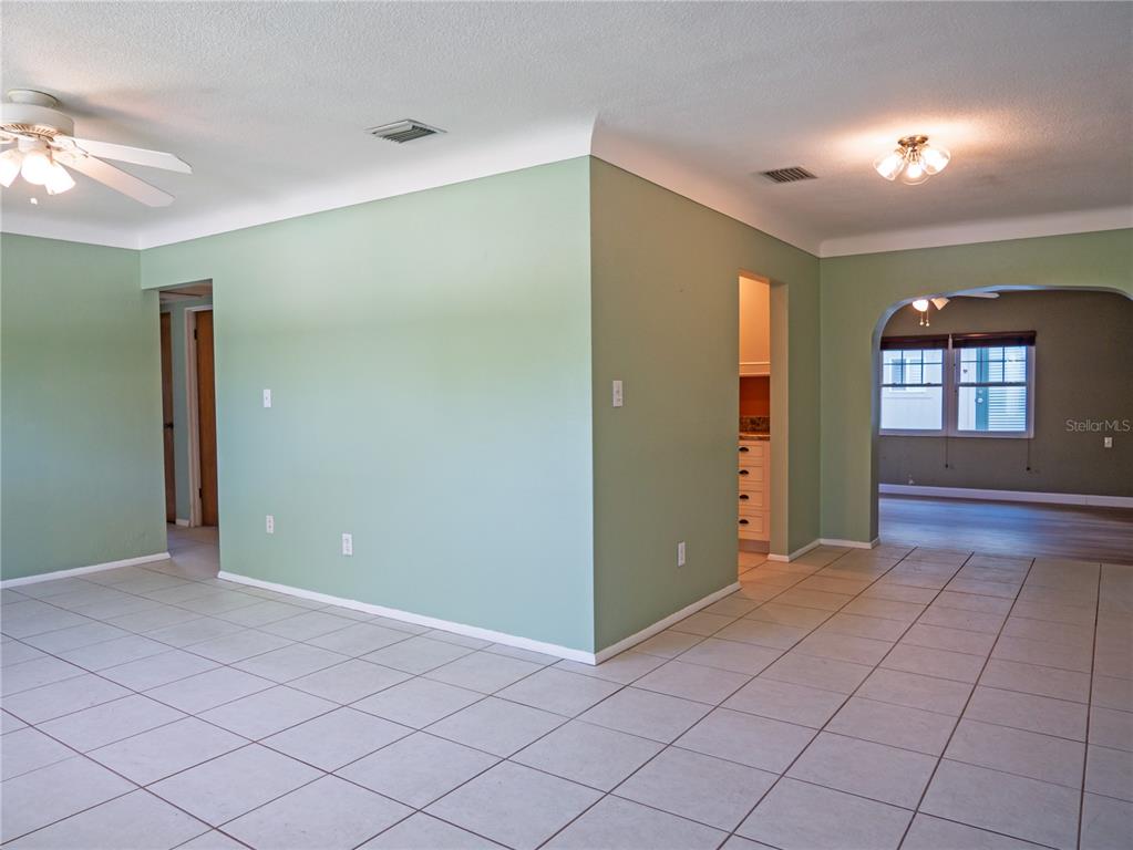 An interior view shows a living area with light green walls and white tile flooring — 6724 17TH LANE N, ST PETERSBURG, FL