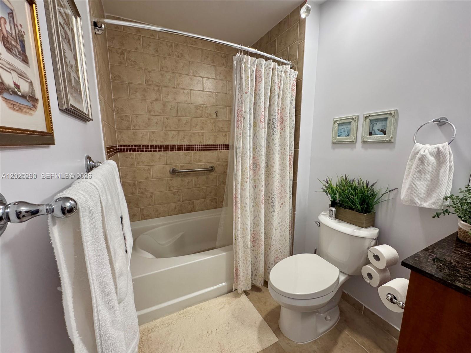 A bathroom features a tiled tub-shower combination, a white toilet, and a vanity — 7355 SW 89th St # 423N, Miami FL 33156, MIAMI, FL