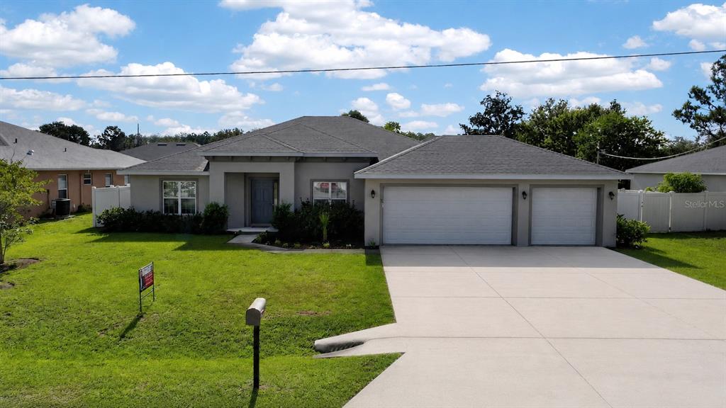 A single-story house with a gray roof, stucco exterior, and a three-car garage — 5 LYNTON PLACE, PALM COAST, FL