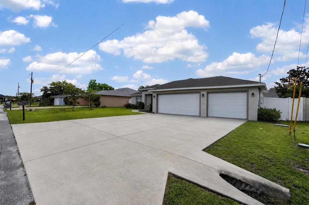 A wide concrete driveway leads to a two-car garage of a single-story suburban house — 5 LYNTON PLACE, PALM COAST, FL