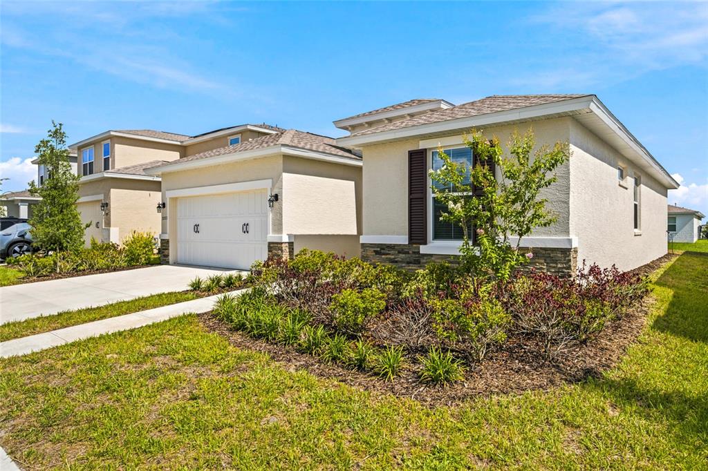 A view of the exterior of two adjacent suburban houses with beige stucco siding — 7227 SW 58TH PLACE ROAD, OCALA, FL