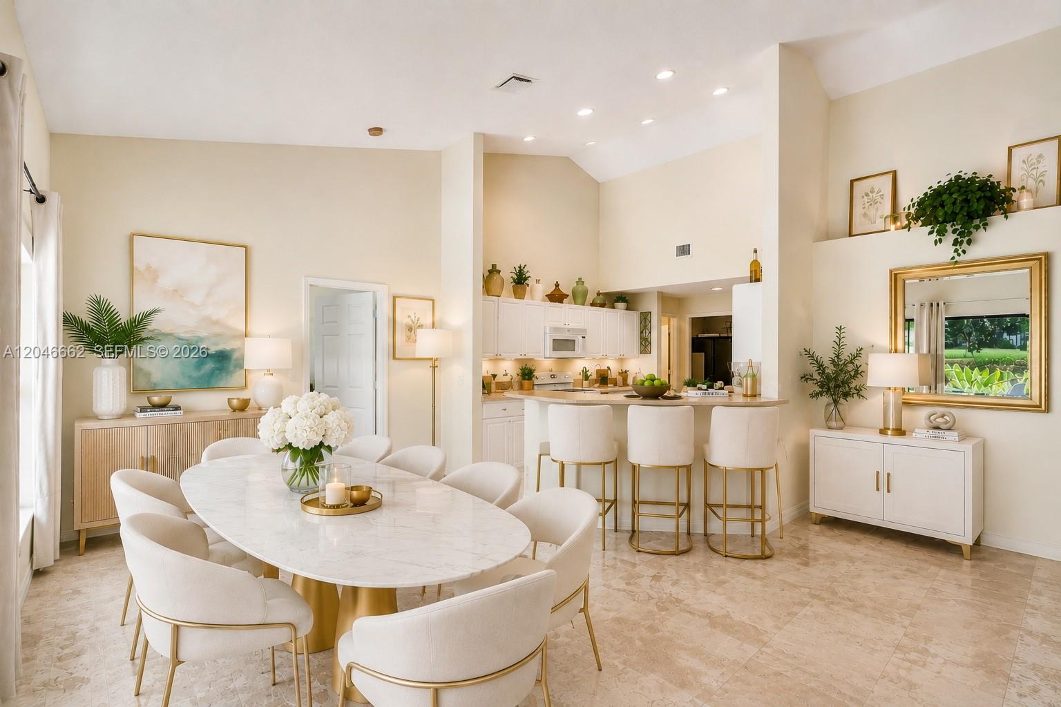 A dining area with an oval marble table and white chairs sits before an open kitchen — 3450 Dunes Vista Dr, Pompano Beach FL 33069, POMPANO BEACH, FL