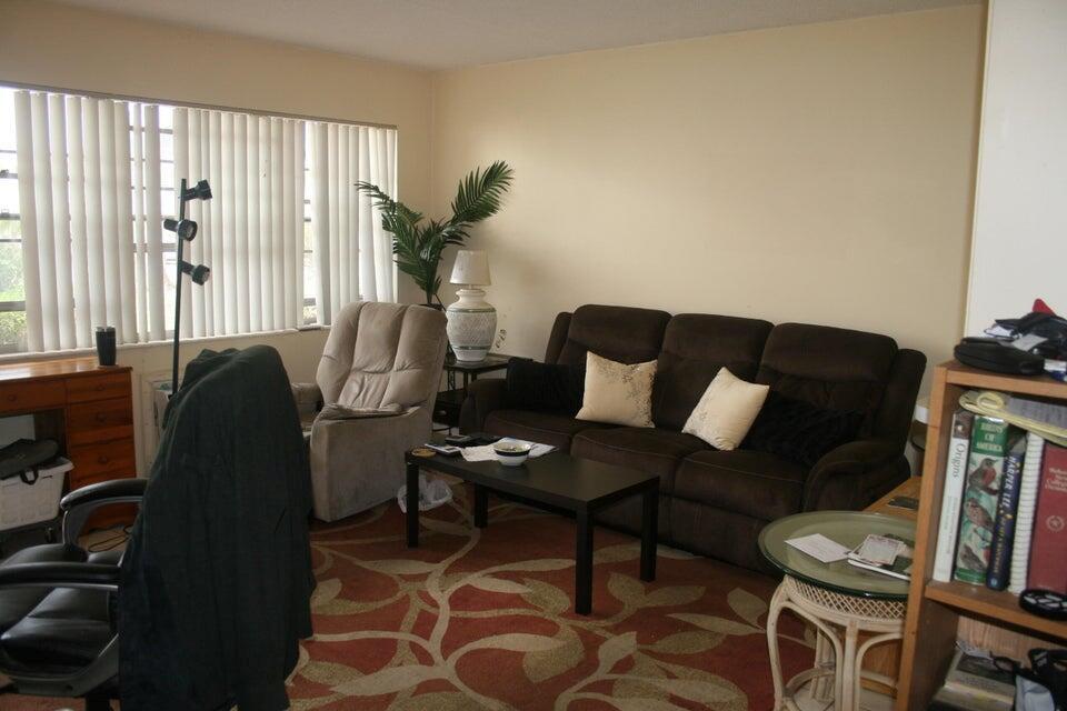 A living room features a brown sofa, a recliner, a coffee table, and a patterned rug — 28 Camden B, West Palm Beach FL 33417, WEST PALM BEACH, FL