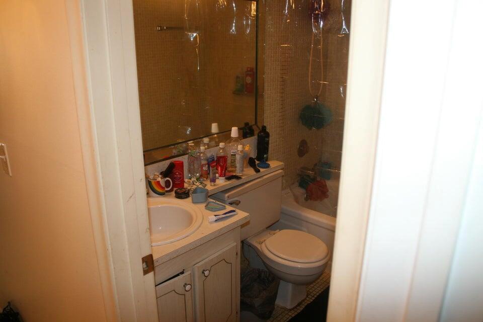 A small bathroom features a vanity with a sink, a toilet, and a shower-tub combination — 28 Camden B, West Palm Beach FL 33417, WEST PALM BEACH, FL