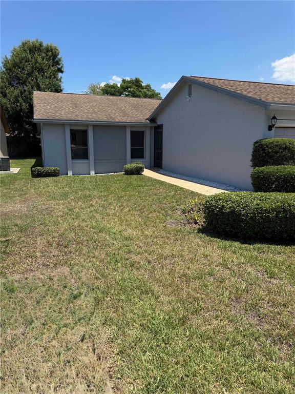 A gray house exterior features a tan shingled roof and a manicured lawn — 4114 FISHERMANS LANDING, WINTER HAVEN, FL
