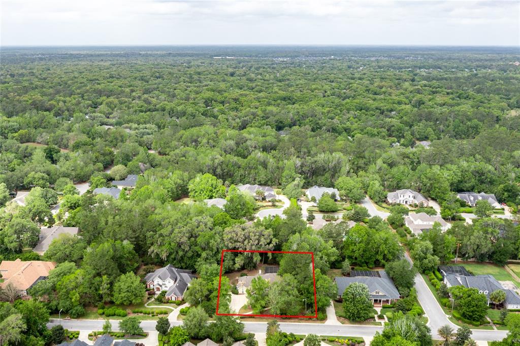 An aerial view shows a single-family home outlined in red, surrounded by dense green trees — 3680 SW 86TH STREET, GAINESVILLE, FL