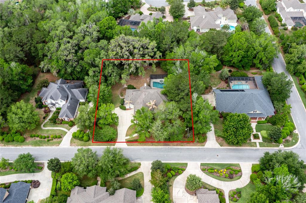 An aerial view shows a single-family home with a pool surrounded by dense trees — 3680 SW 86TH STREET, GAINESVILLE, FL