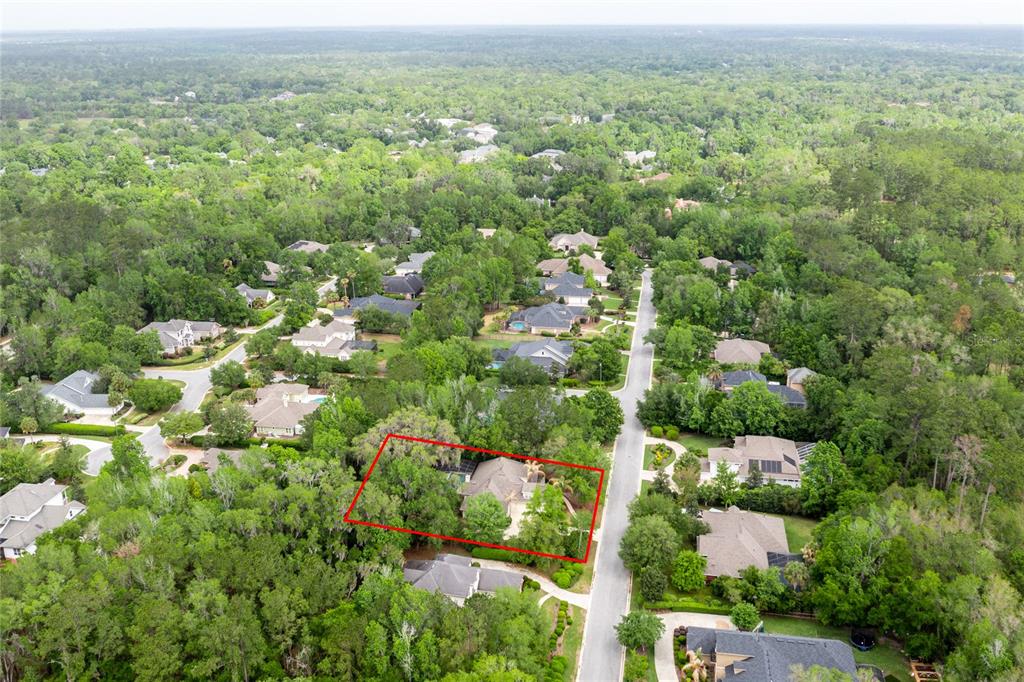 A single-story house with stone siding, light-colored trim, and a curved walkway among trees — 3680 SW 86TH STREET, GAINESVILLE, FL