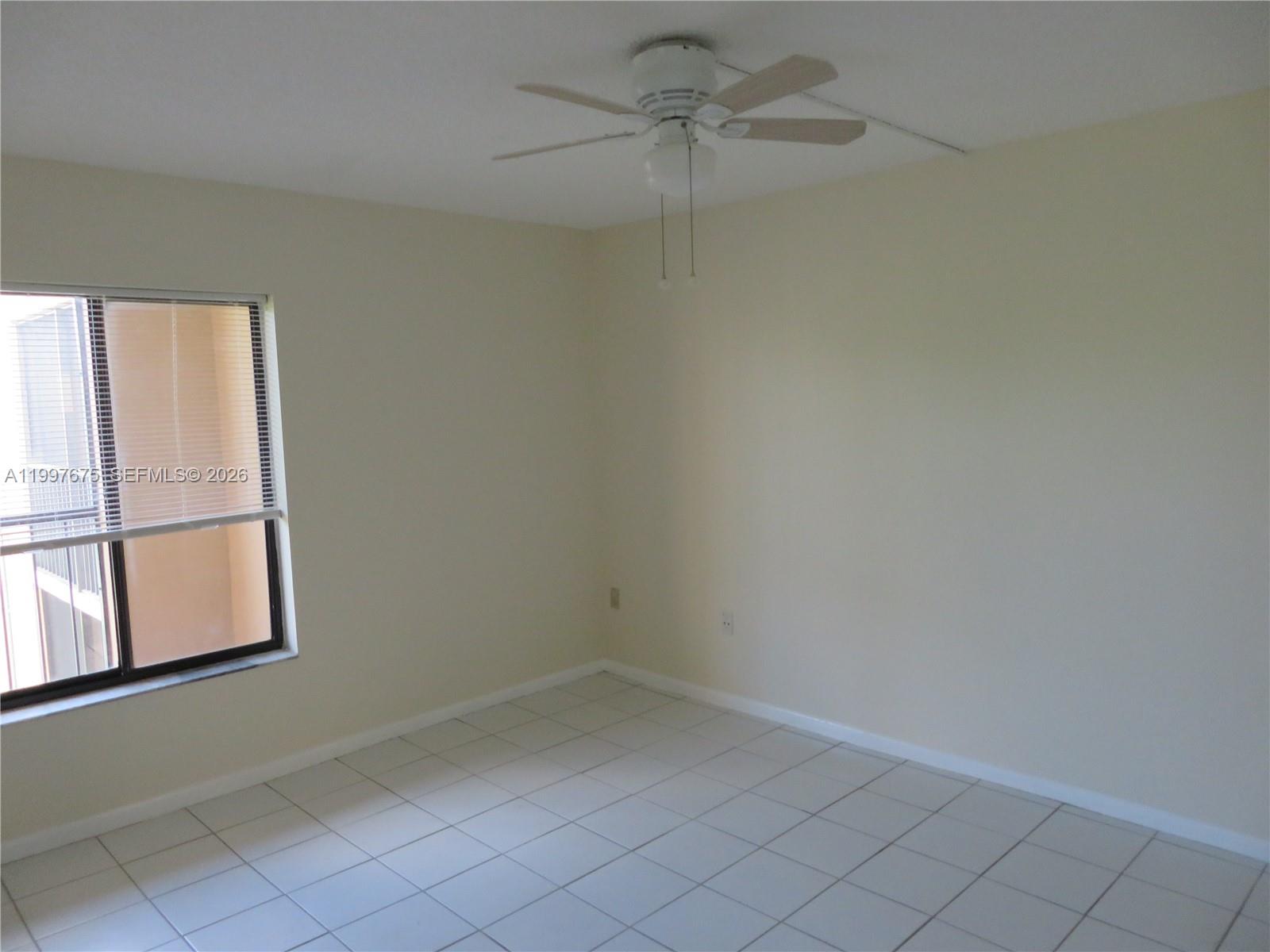 A kitchen features white cabinets, wood-look laminate countertops, stainless steel appliances, and white tile flooring — 8005 SW 107th Ave # 309, Miami FL 33173, MIAMI, FL