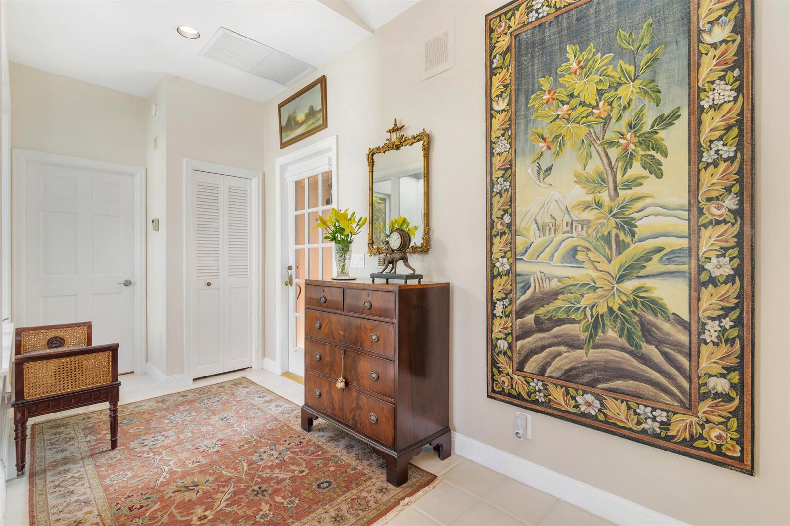 A foyer features a wooden chest of drawers, a large wall tapestry, and a patterned rug — 12079 SE Birkdale Run, Jupiter FL 33469, JUPITER, FL