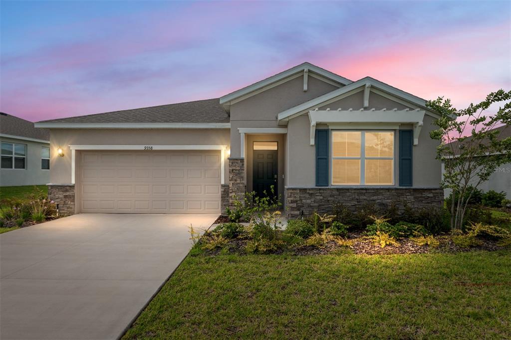 A single-story suburban house features a two-car garage, stone veneer accents, and a front porch — 9358 SW 60TH TERRACE ROAD, OCALA, FL
