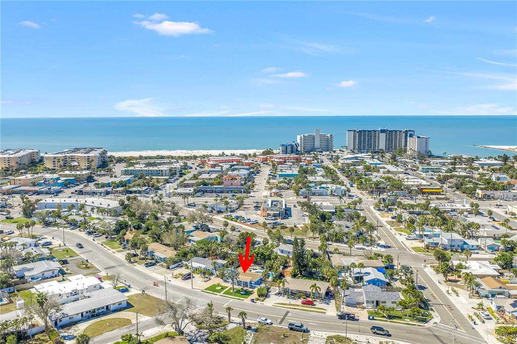 An aerial view shows a single-story house with a pool near a coastal beach town — 6892 GULF WINDS DRIVE UNIT 1, ST PETE BEACH, FL