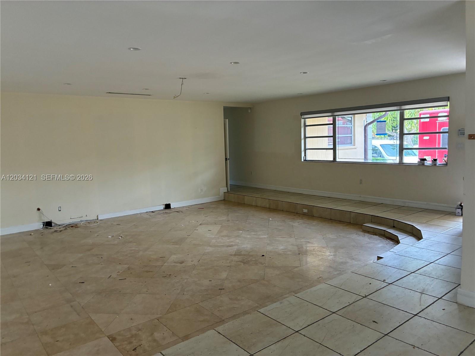 A single-story house with a tan exterior, a circular driveway, and a manicured hedge — 18715 NE 18th Ave, Miami FL 33179, MIAMI, FL
