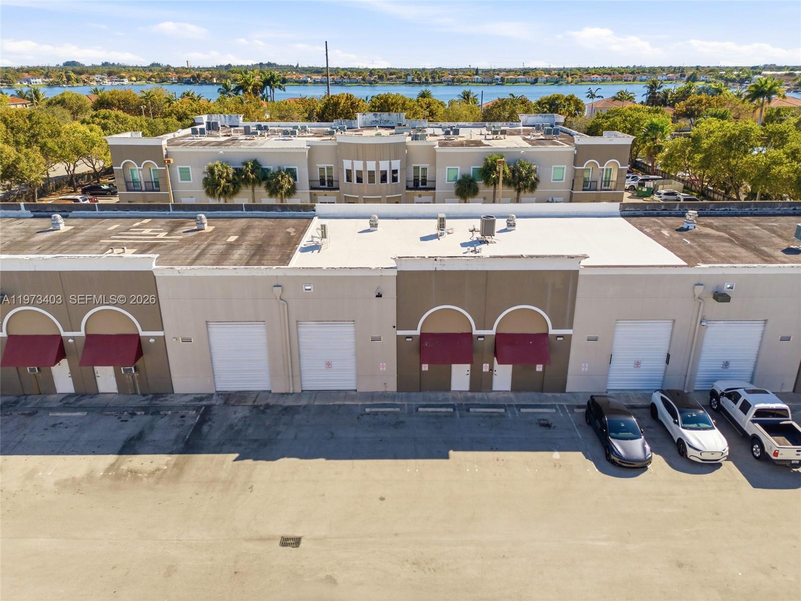 An aerial view shows a commercial building with roll-up doors and a parking lot — 13500 SW 134th Ave # 4A, Miami FL 33186, MIAMI, FL