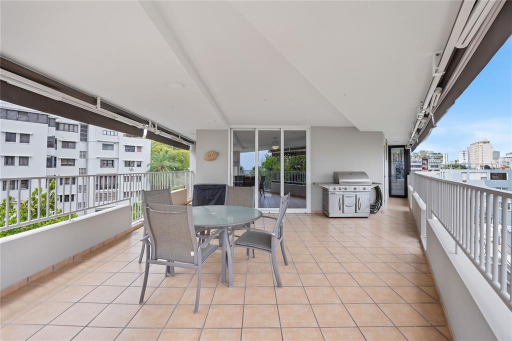 A spacious outdoor balcony features a dining set, a grill, and metal railings — 1520 ASHFORD AVE UNIT 4, SAN JUAN, PR