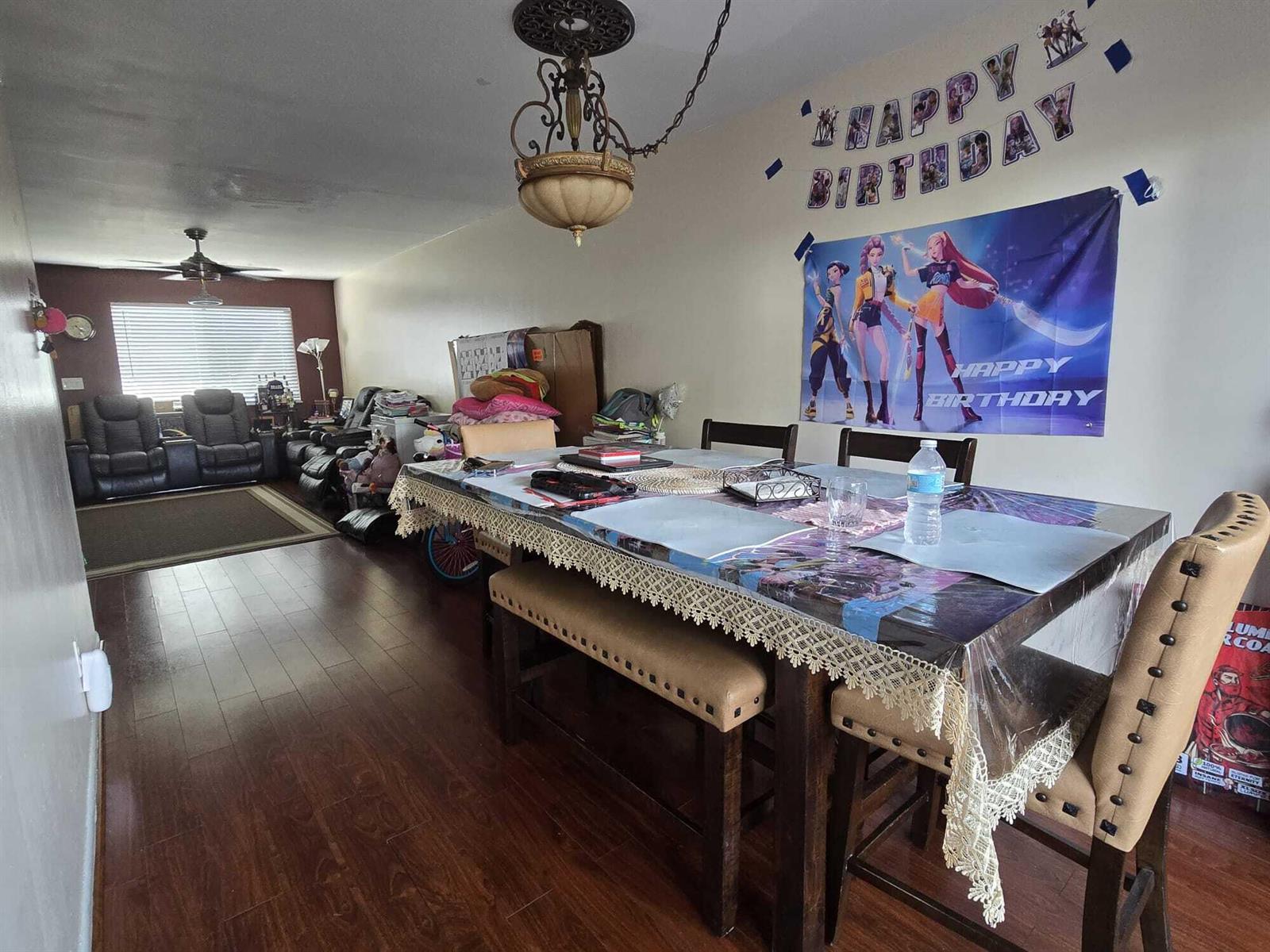 A dining area with a wooden table, upholstered chairs, and a birthday banner on the wall — 5204 Bayside Drive # 5204, FL 33463, FL