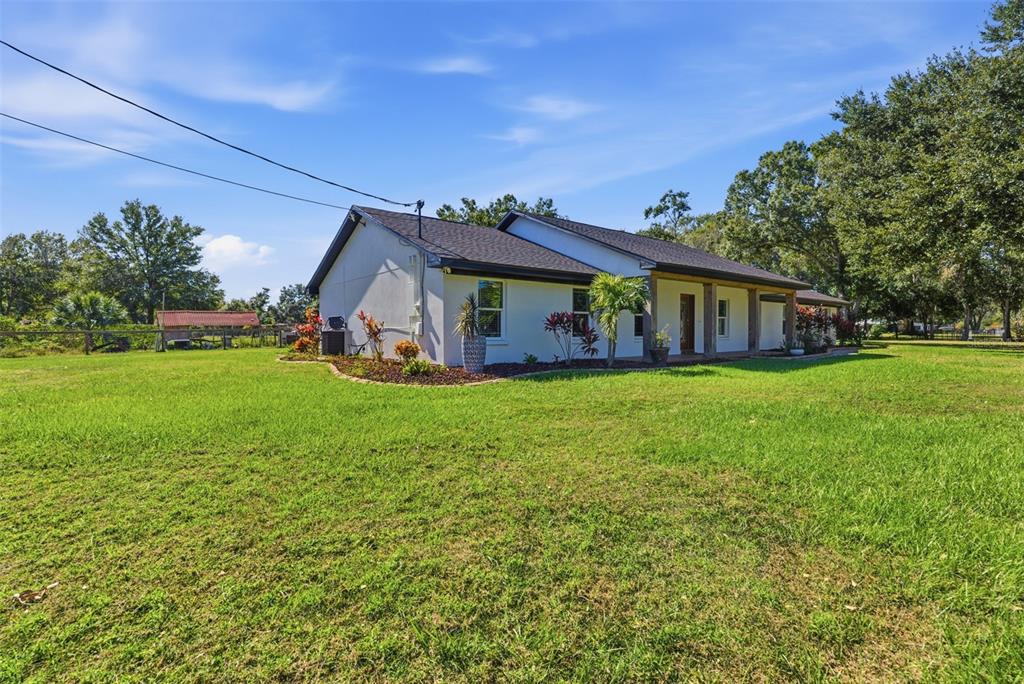 A single-story house with a white exterior and a covered porch sits on a lawn — 2506 HAWK GRIFFIN ROAD, PLANT CITY, FL