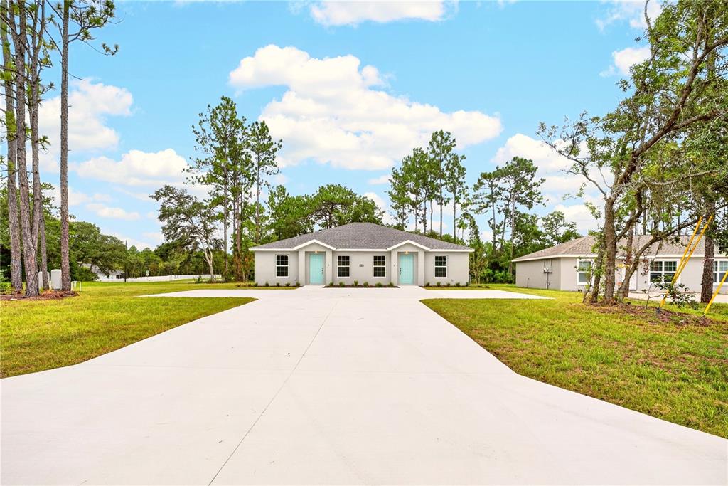 A single-story duplex with light gray siding and two light blue front doors — 14001 SW 60TH TERRACE, OCALA, FL