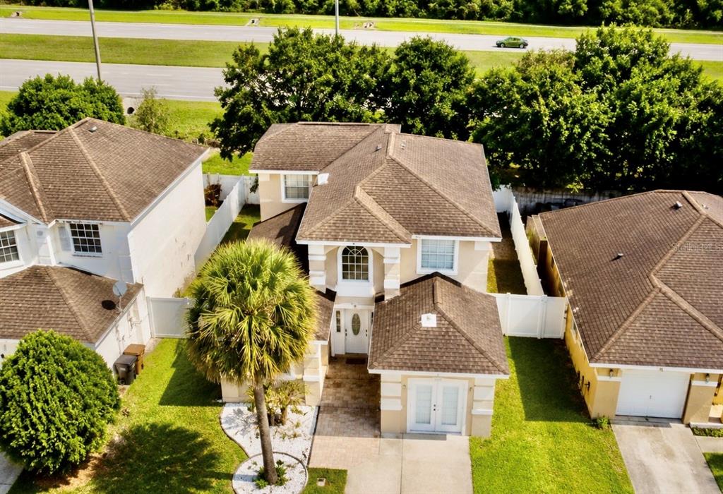 An aerial view shows a two-story suburban house with a brown roof and palm tree — 2728 EMERSON LANE, KISSIMMEE, FL